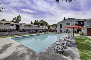 our apartments have a swimming pool with chairs and a umbrella at Gateway, Chico, CA 95926